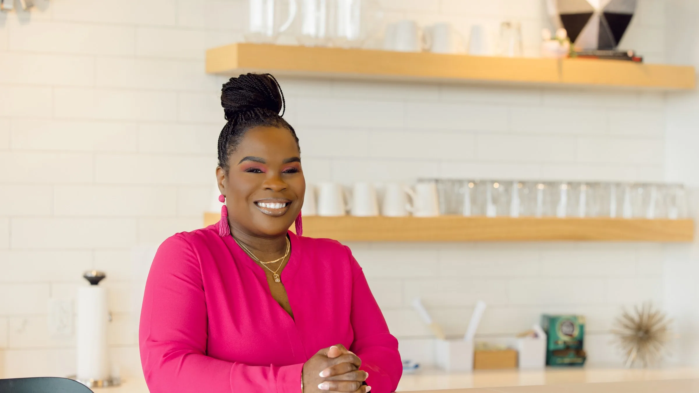 Latisha Newby smiling, leaning on a counter.