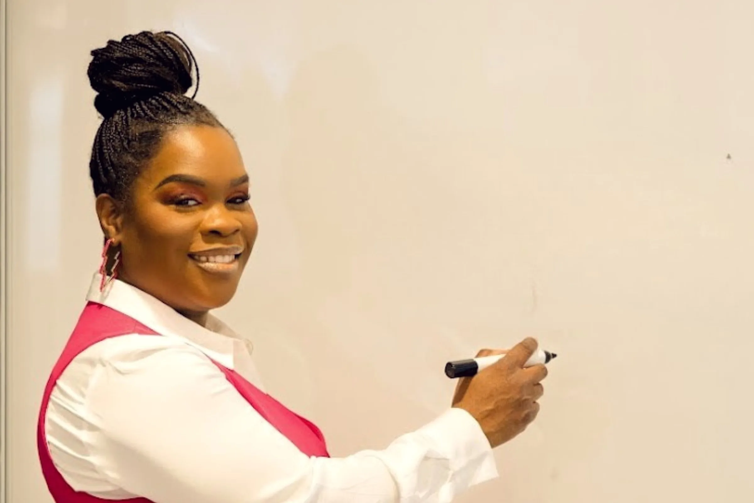 Latisha Newby speaking at a whiteboard.