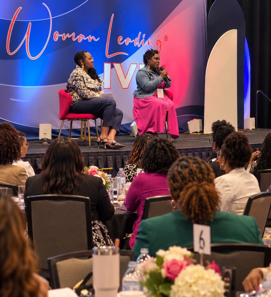 Two speakers in conversation on stage at Woman Leading Live, in front of a seated audience.