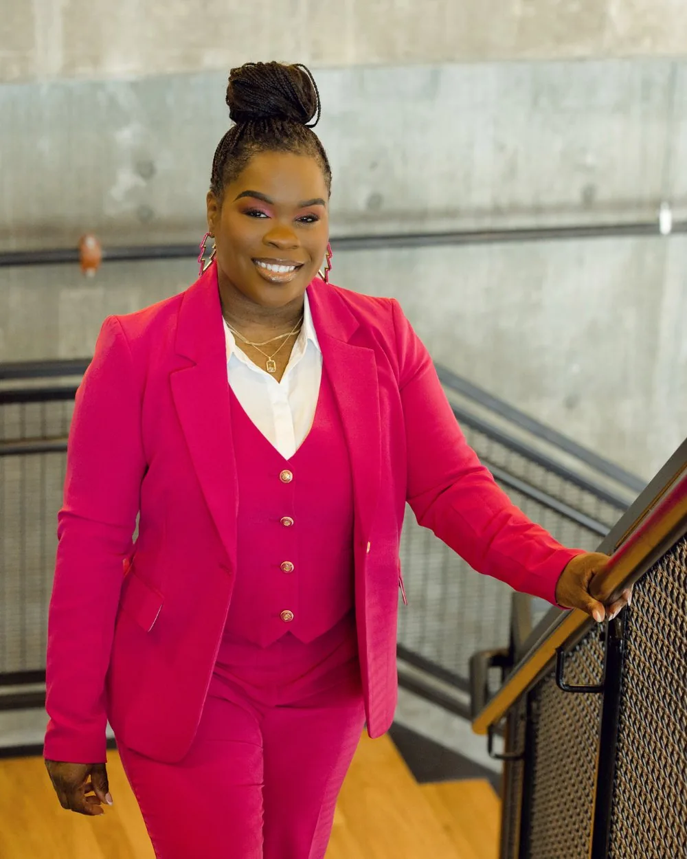 Latisha Newby, founder of Cultivate HR Consulting, on a staircase in a hot pink suit.
